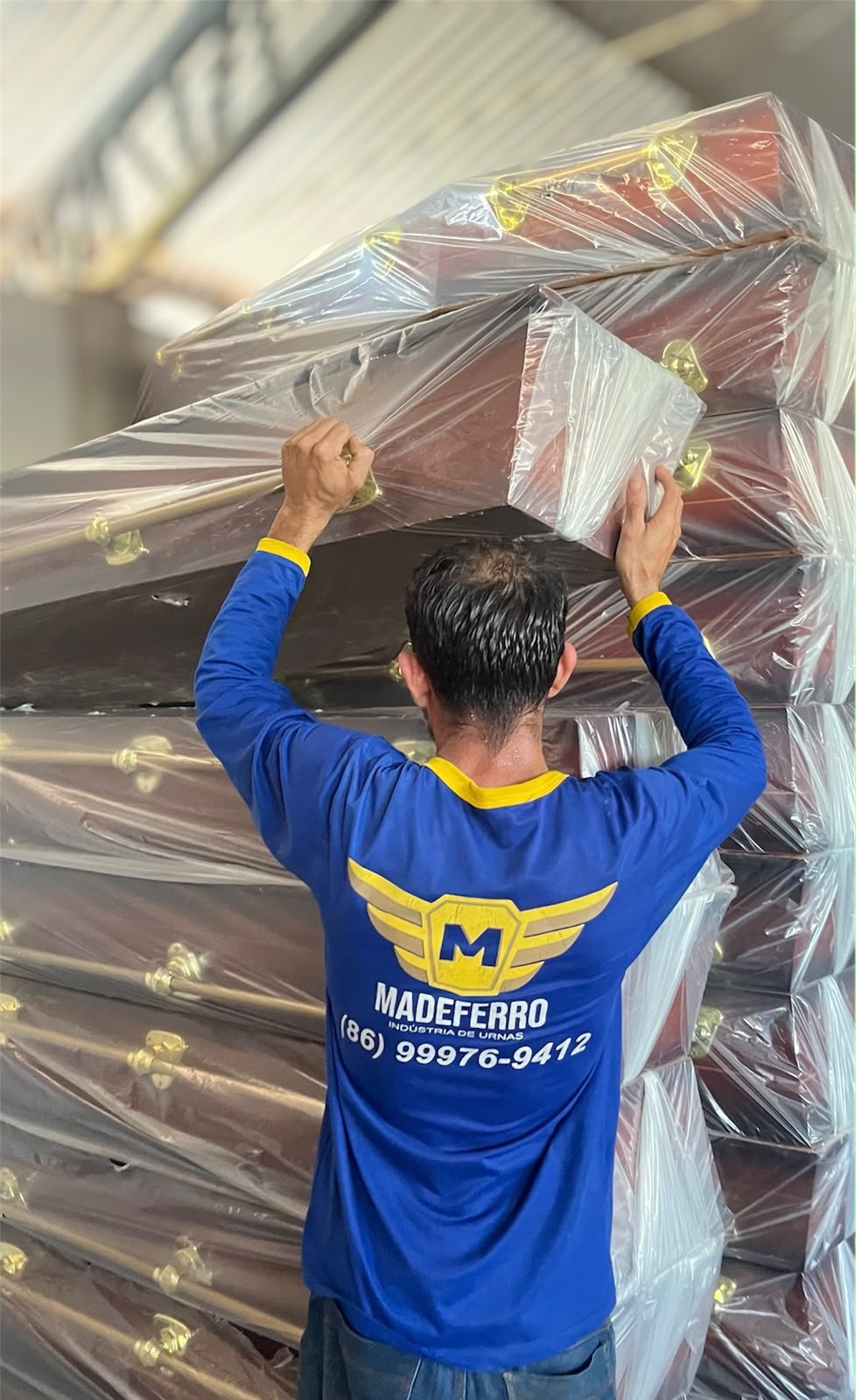 Funcionário da Madeferro carregando urnas embaladas para transporte